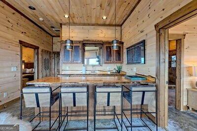 kitchen with wood walls, wooden ceiling, and a kitchen breakfast bar