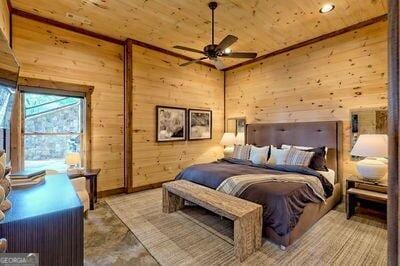 bedroom with wood walls, wooden ceiling, and ceiling fan