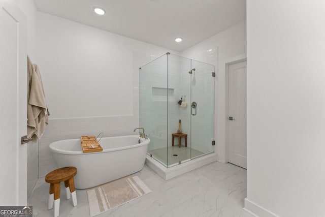 bathroom with separate shower and tub and tile walls