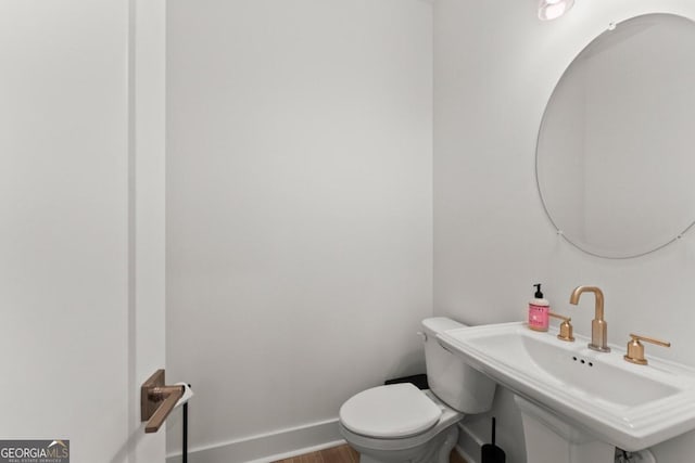 bathroom with hardwood / wood-style flooring, sink, and toilet