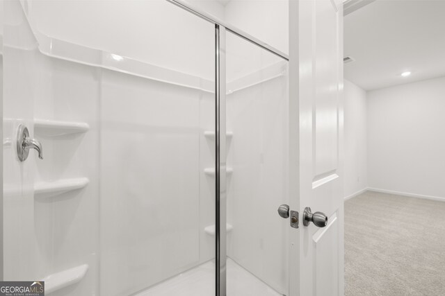 bathroom featuring a shower with door