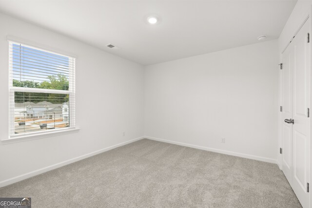 carpeted empty room with a healthy amount of sunlight