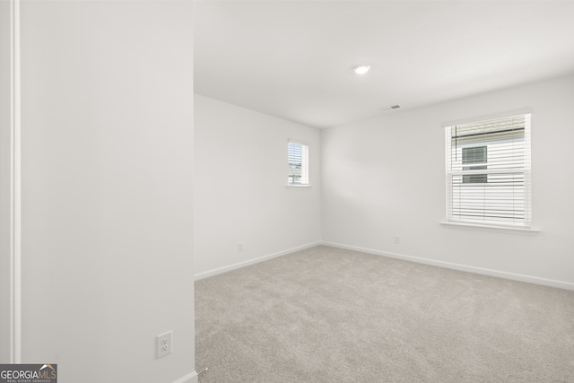 unfurnished room featuring light carpet