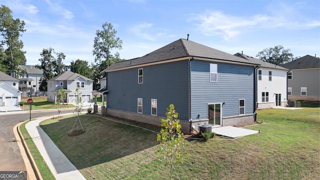 view of side of home with a garage, a lawn, and central AC