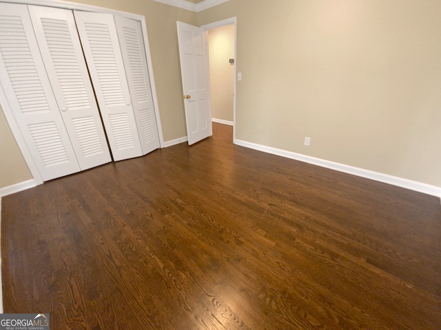 unfurnished bedroom featuring a closet and dark hardwood / wood-style flooring