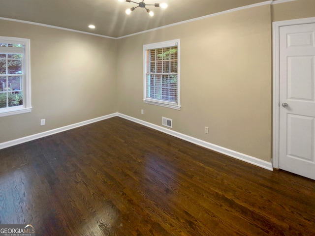 unfurnished room with ornamental molding, an inviting chandelier, and dark hardwood / wood-style flooring