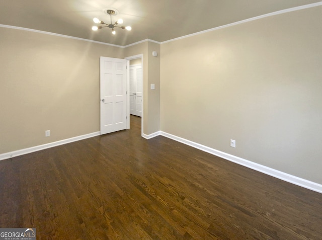 unfurnished room featuring ornamental molding, a notable chandelier, and dark hardwood / wood-style flooring