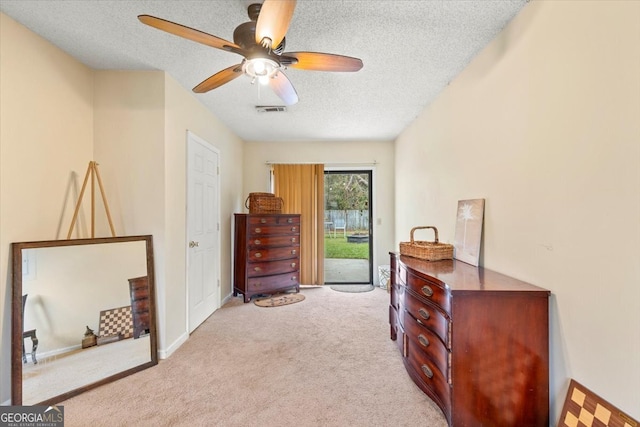 interior space featuring a textured ceiling, light colored carpet, ceiling fan, and access to outside