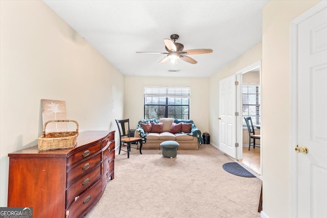 sitting room with light colored carpet and ceiling fan