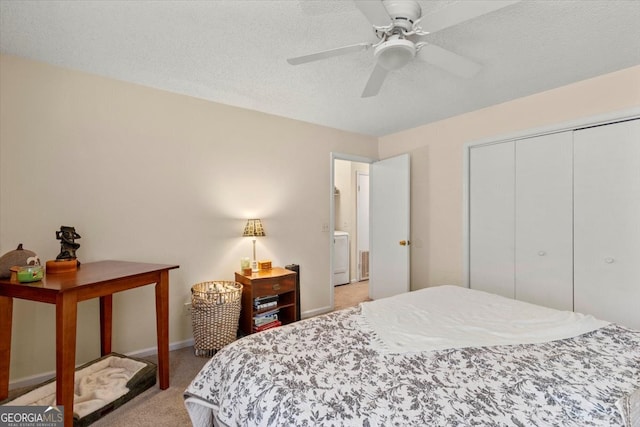 bedroom featuring ceiling fan, a textured ceiling, a closet, washer / dryer, and light colored carpet