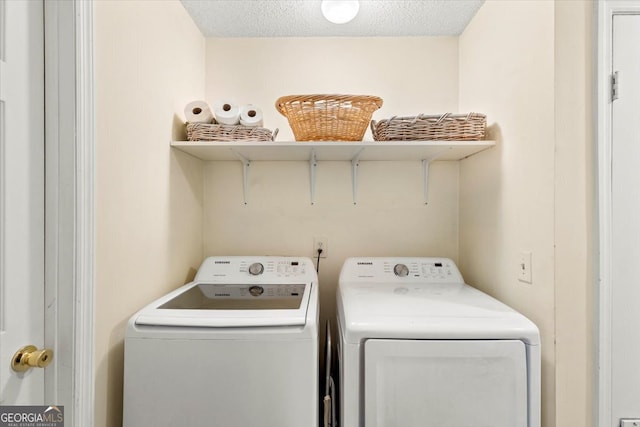 laundry room with separate washer and dryer and a textured ceiling