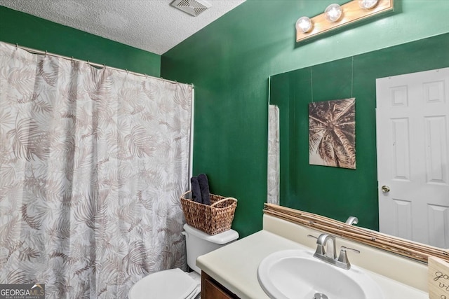 bathroom featuring a textured ceiling, vanity, and toilet