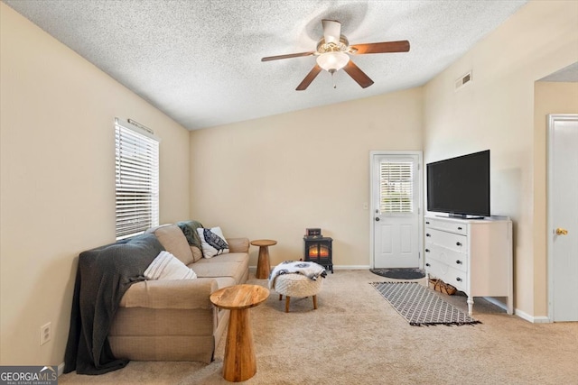 living room with light carpet, ceiling fan, vaulted ceiling, and a textured ceiling