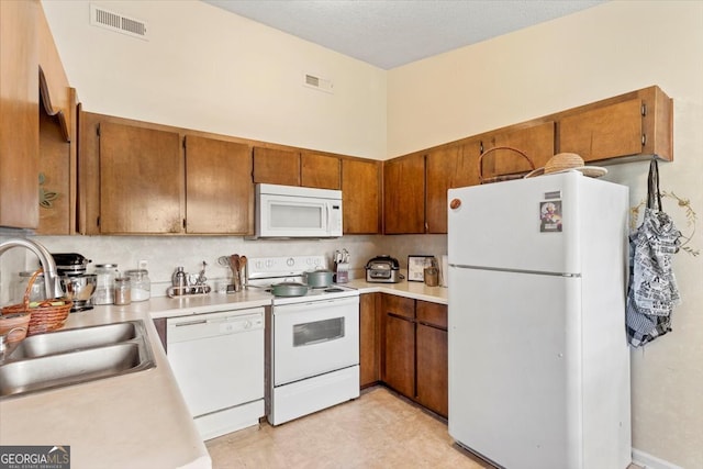 kitchen featuring white appliances, sink, and a textured ceiling