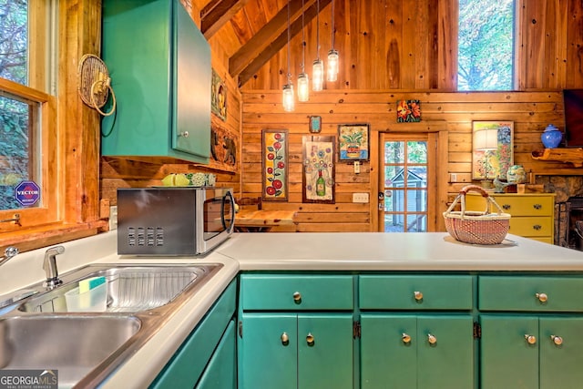 kitchen featuring green cabinetry, wood walls, and plenty of natural light