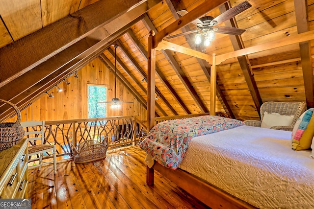 bedroom with wood-type flooring, lofted ceiling with beams, wood walls, and wood ceiling