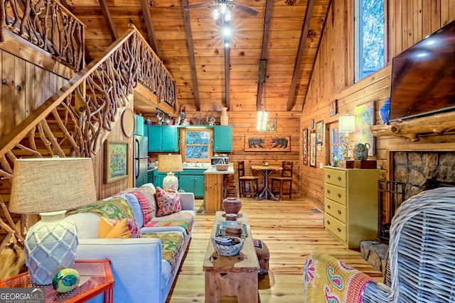 living room featuring vaulted ceiling with beams, wood walls, wood ceiling, and light hardwood / wood-style flooring