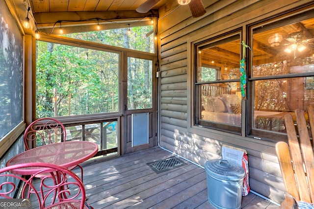 sunroom featuring plenty of natural light, wood ceiling, vaulted ceiling with beams, and ceiling fan