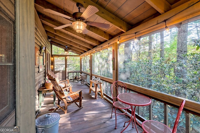 unfurnished sunroom with ceiling fan, vaulted ceiling with beams, and wood ceiling