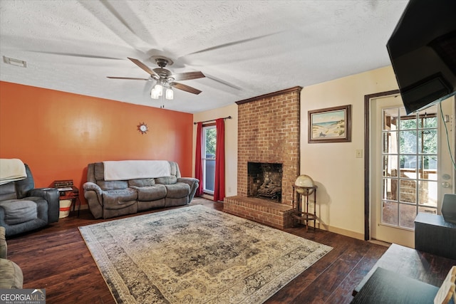 living room featuring ceiling fan, a textured ceiling, dark hardwood / wood-style flooring, and a wealth of natural light