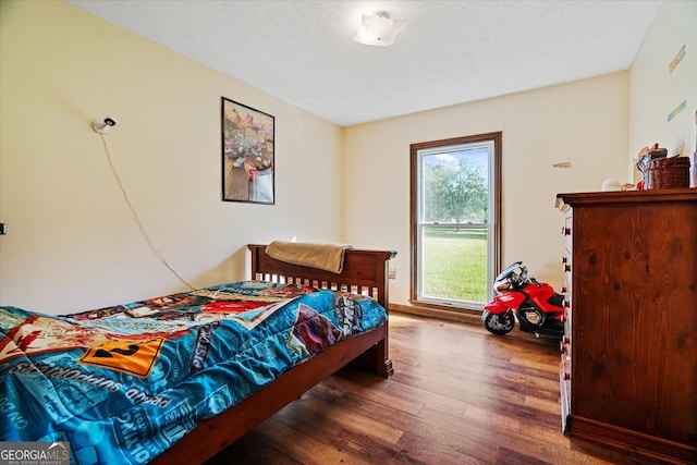 bedroom featuring a textured ceiling and dark hardwood / wood-style floors