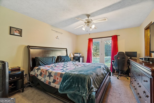 carpeted bedroom with access to outside, a textured ceiling, and ceiling fan