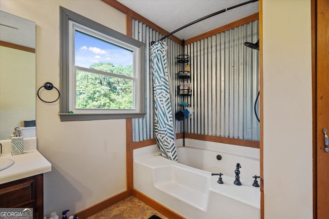 bathroom featuring vanity, shower / bath combo with shower curtain, a textured ceiling, and tile patterned floors