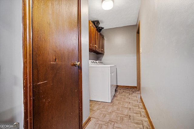 clothes washing area with cabinets, a textured ceiling, washing machine and clothes dryer, and light parquet floors