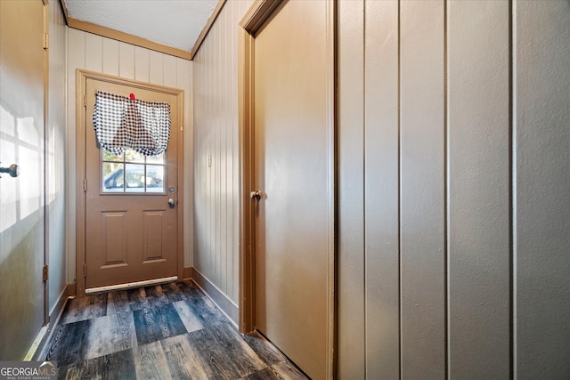 entryway with ornamental molding, wood walls, and dark hardwood / wood-style floors