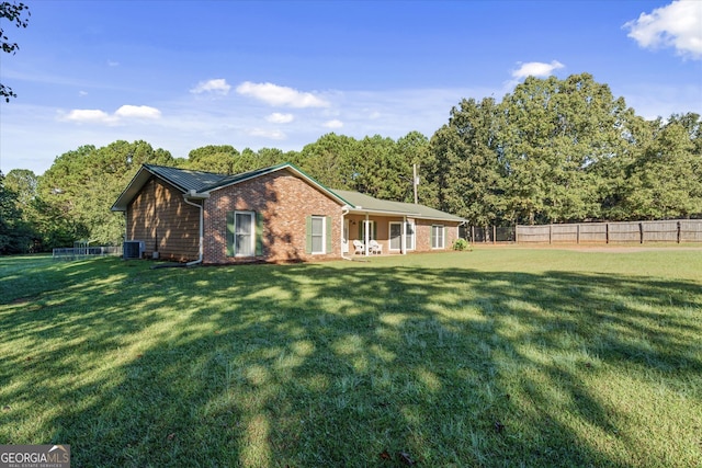 exterior space with a lawn and central AC