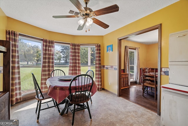 dining space featuring ceiling fan, a textured ceiling, light hardwood / wood-style flooring, and a wealth of natural light