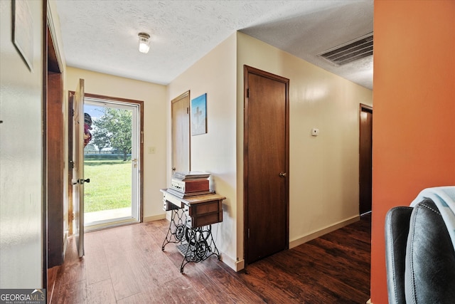 hallway featuring hardwood / wood-style floors and a textured ceiling