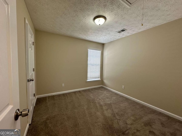 carpeted empty room featuring a textured ceiling