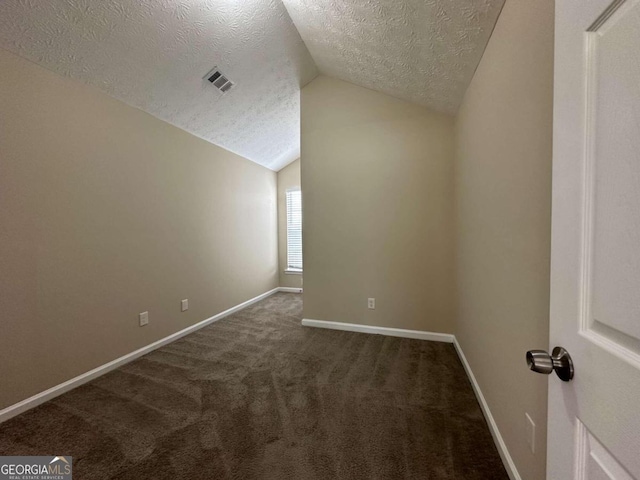 bonus room featuring lofted ceiling, dark carpet, and a textured ceiling