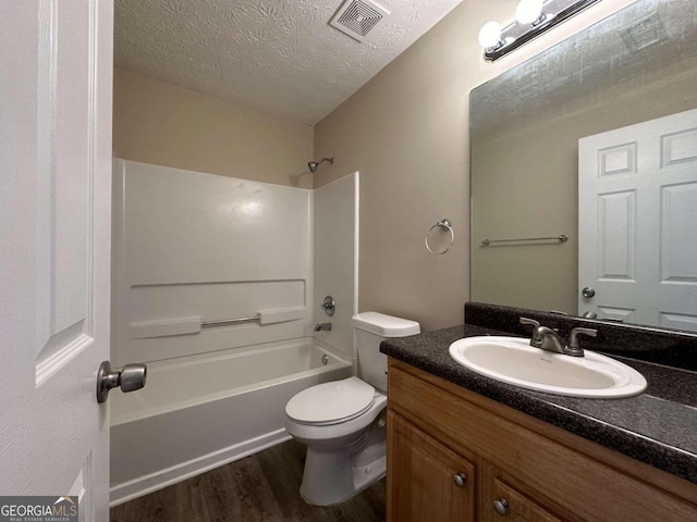 full bathroom with vanity, tub / shower combination, wood-type flooring, a textured ceiling, and toilet