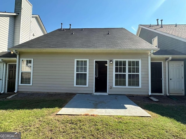 back of property featuring a lawn and a patio area