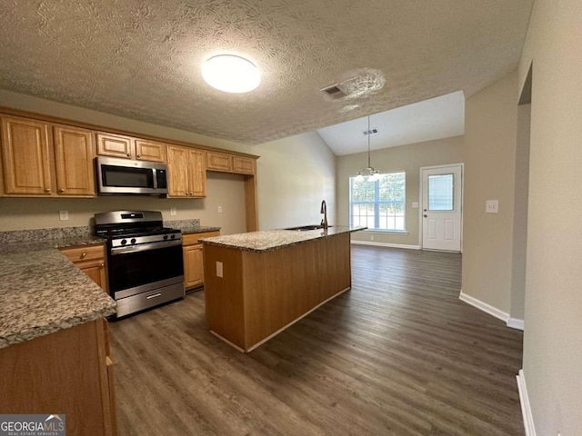 kitchen with appliances with stainless steel finishes, pendant lighting, dark wood-type flooring, and a center island