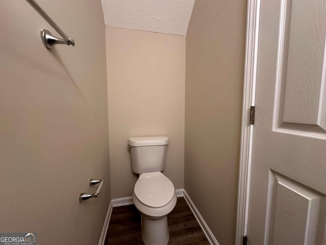 bathroom featuring hardwood / wood-style flooring, toilet, and a textured ceiling