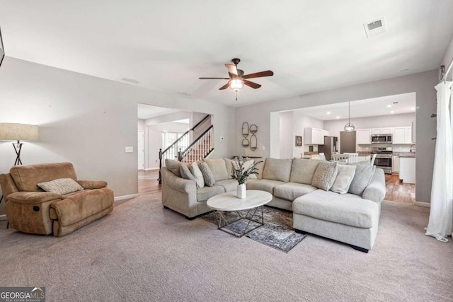 carpeted living room featuring ceiling fan