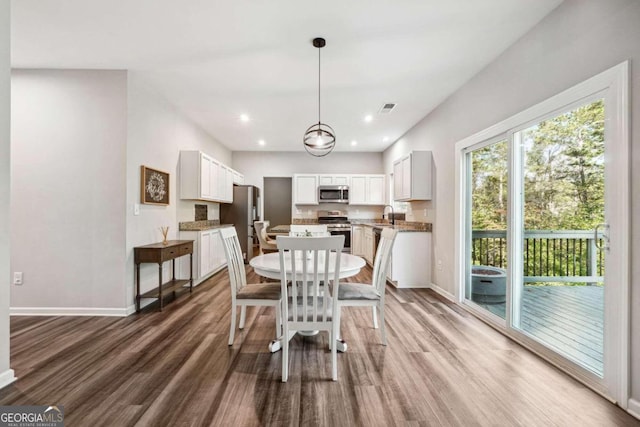 dining space with hardwood / wood-style flooring and sink