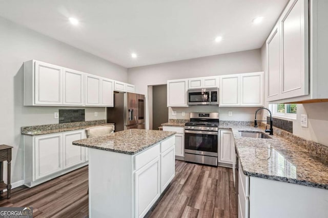 kitchen featuring a kitchen island, sink, stainless steel appliances, dark hardwood / wood-style floors, and white cabinets