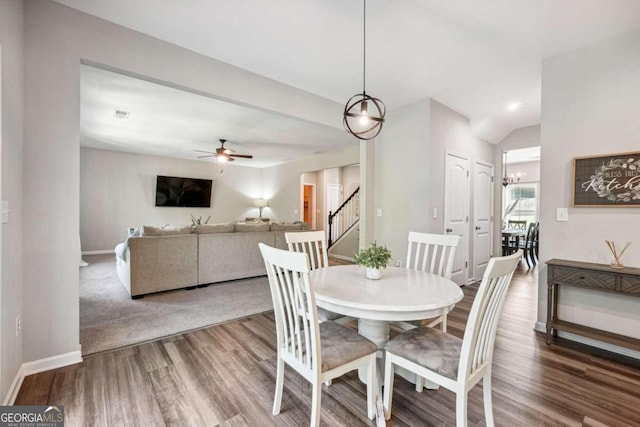 dining space with ceiling fan, hardwood / wood-style flooring, and vaulted ceiling