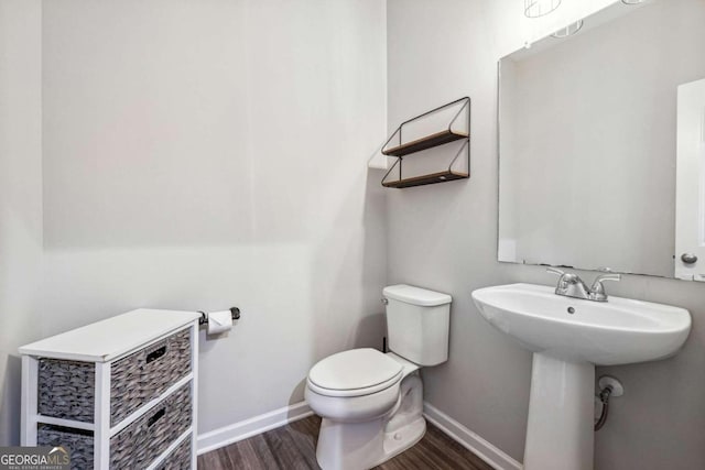 bathroom featuring hardwood / wood-style flooring, sink, and toilet