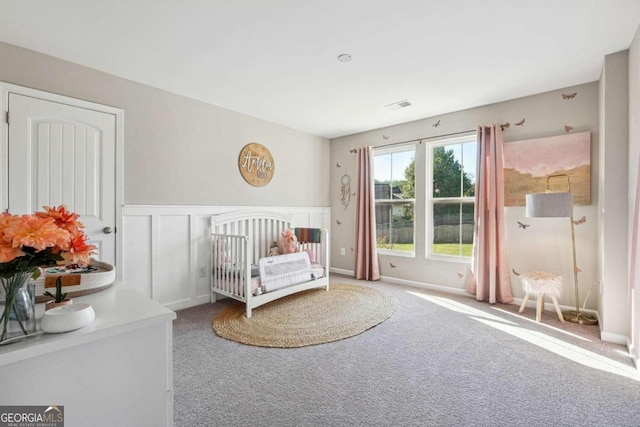 unfurnished bedroom featuring carpet floors and a nursery area