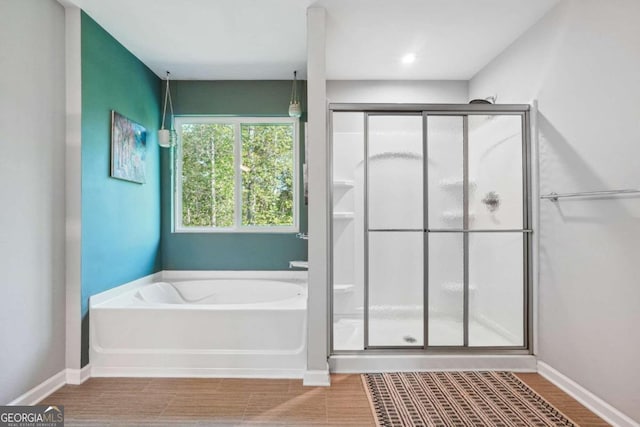 bathroom featuring wood-type flooring and separate shower and tub