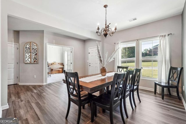 dining space with a chandelier and dark hardwood / wood-style flooring