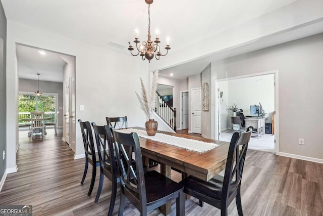 dining space with dark hardwood / wood-style floors and a chandelier