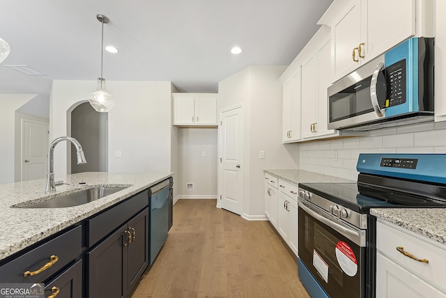 kitchen with sink, light stone counters, white cabinetry, pendant lighting, and stainless steel appliances