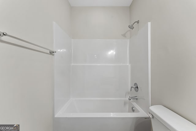 bathroom featuring tub / shower combination and toilet