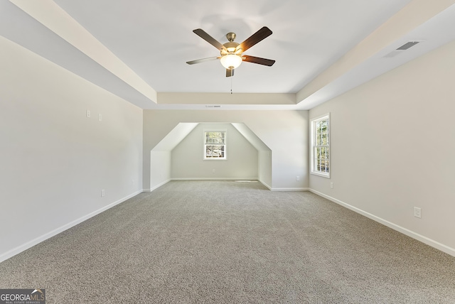 bonus room with ceiling fan, plenty of natural light, and carpet